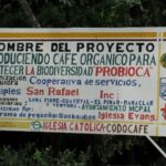Road sign for the San Raphael Cooperative indicating the member groups and two of their core tenets, organic growing and biodiversity preservation. Photo by Barth Anderson.